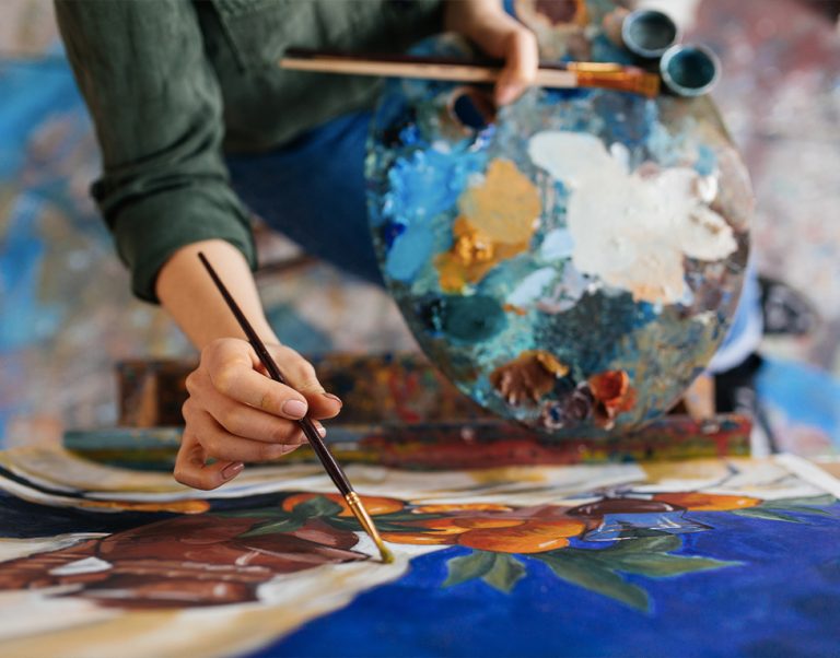 Pincel, paleta de cores e pintura em execução